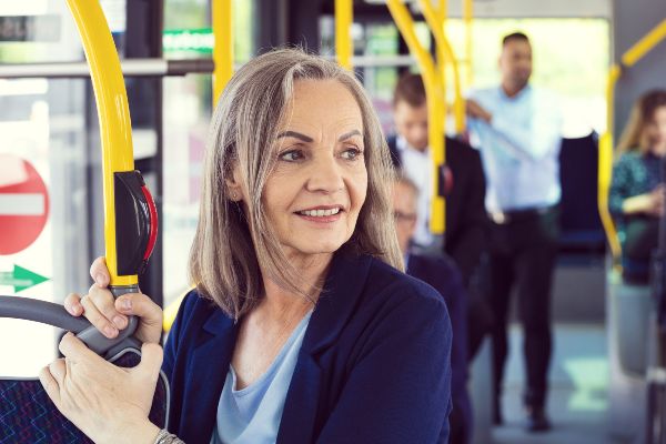 Older woman using bus. Government pledges £80 million to support buses into 2025